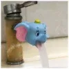 חיבור לברז בצורת פיל כחול וחמוד עם אוזניים ורודות שופך מים לכיור. לפיל יש כיפה צהובה על ראשו, והרקע כולל חלק מהכיור ומצינור הברז.