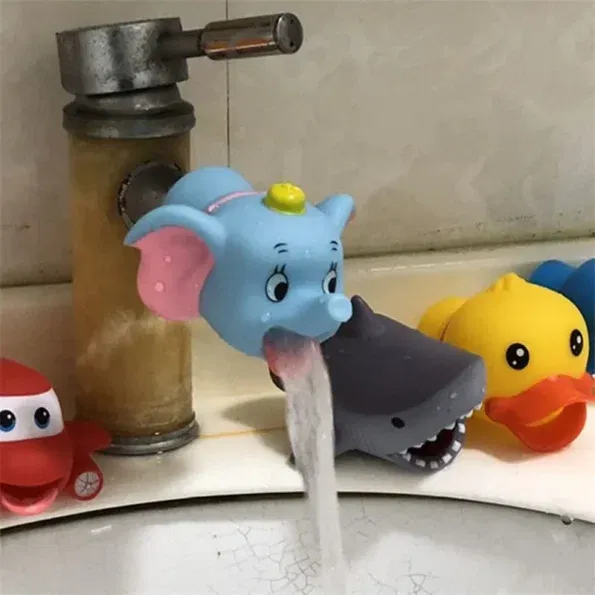 כיור אמבטיה עם מים זורמים מחיבור לברז בצורת פיל. דמויות צעצוע, כולל מטוס, ברווז וכריש, מונחות סביב קצה הכיור.